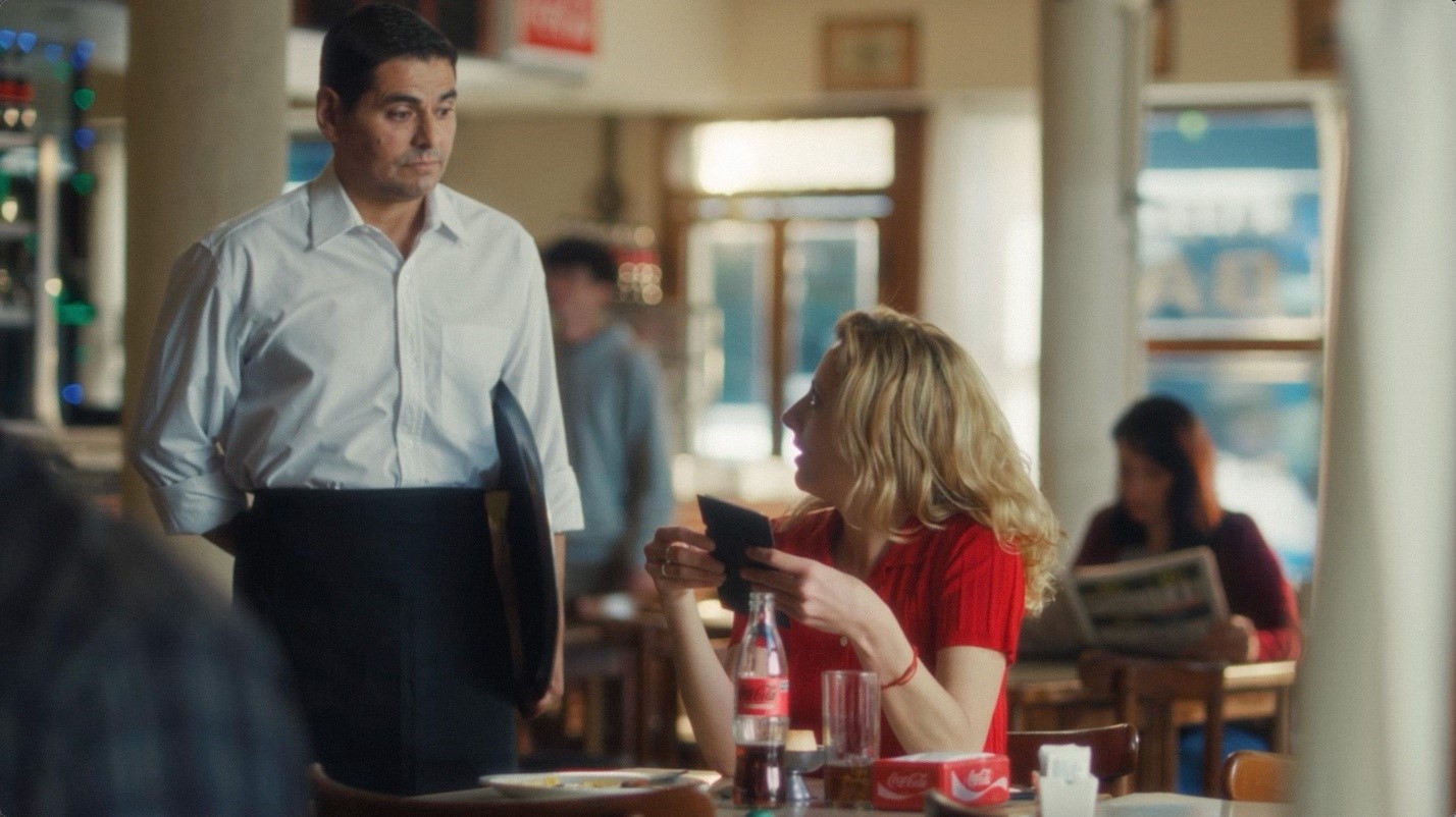 Un mozo atendiendo a una señora en un bar en el marco de  una nueva edición de su campaña nacional.