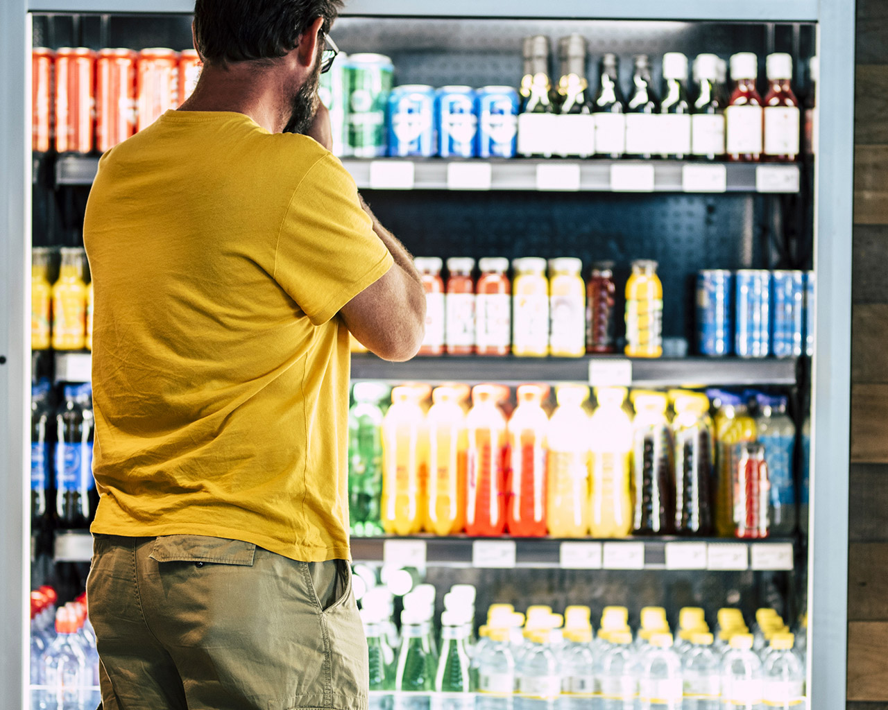 Man staat in winkel voor een gamma dranken