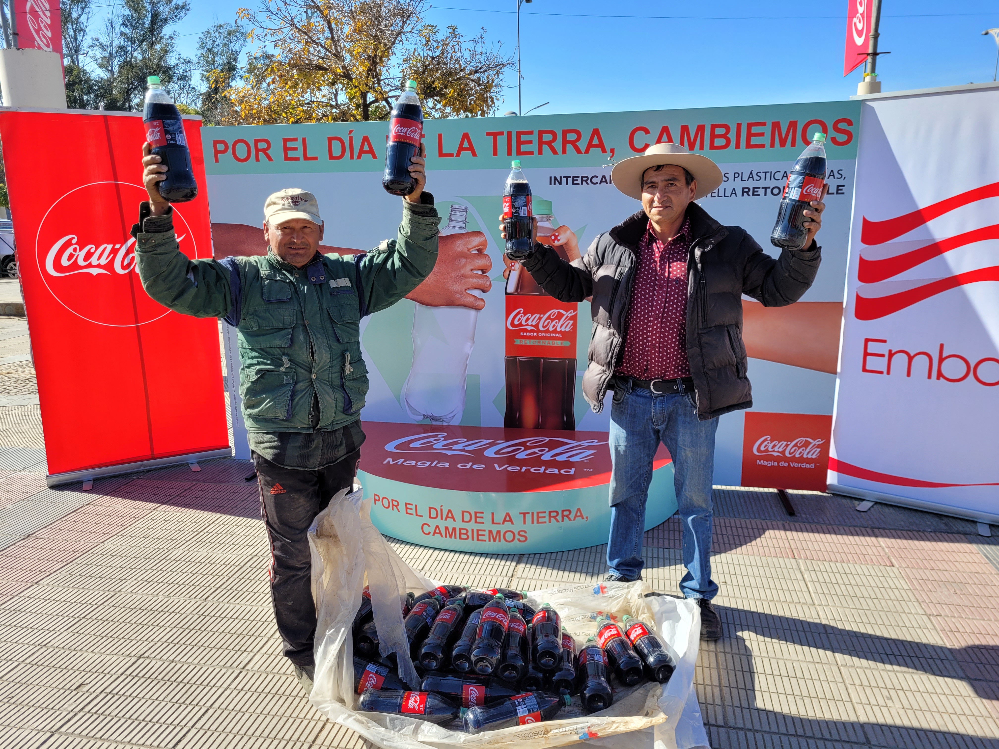 Dos hombres con botellas de Coca-Cola en las manos