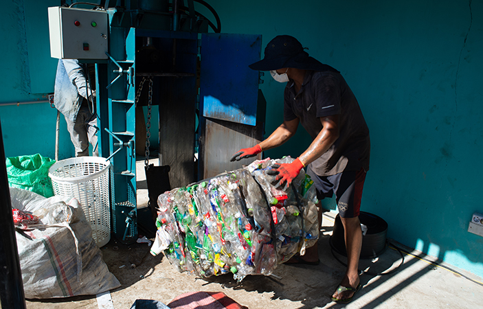Un recolector de Santa Cruz utiliza la compactadora de botellas y cartón