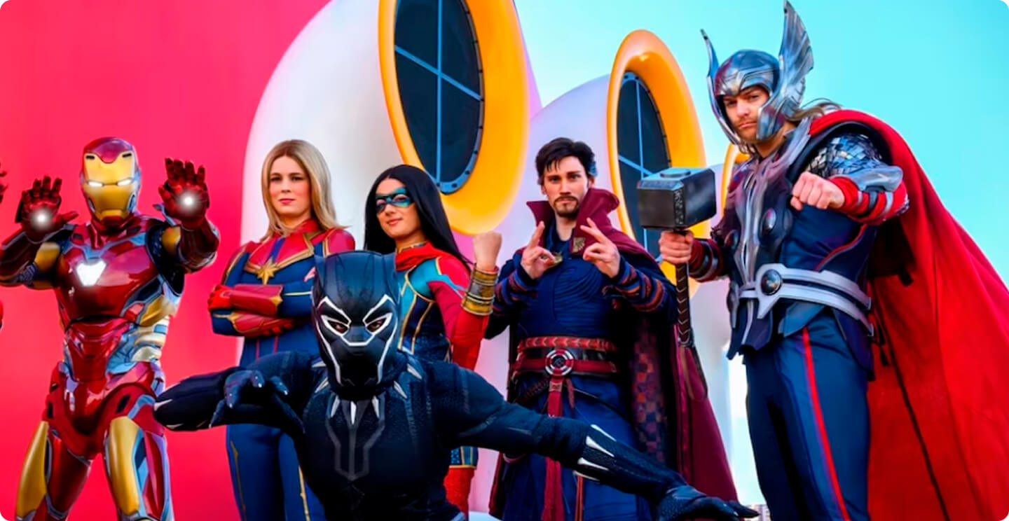 Um grupo de pessoas vestidas com fantasias de super-heróis do Homem de Ferro, Pantera Negra, Doutor Estranho e Thor no convés do Disney Cruise.