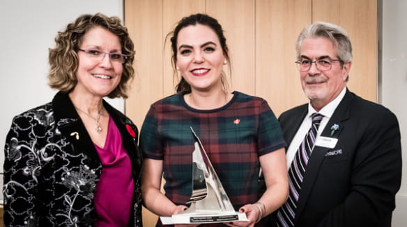 Three people accepting an award from the Canadian Museum of Nature in Ottawa, ON 