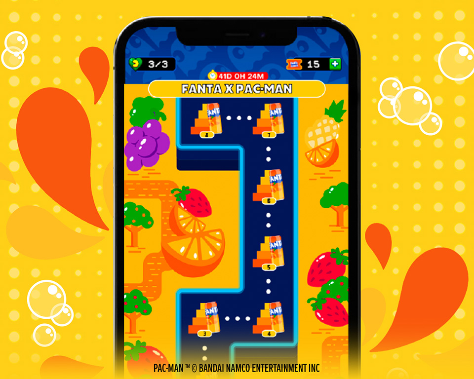 Interfaz del juego para celulares Android y IPhone de Tropical Pac-Man que muestra un nivel del laberinto con frutas y los fantasmas de colores.