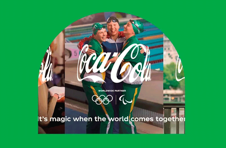 Three Olympic athletes hugging with the Coca-Cola logo