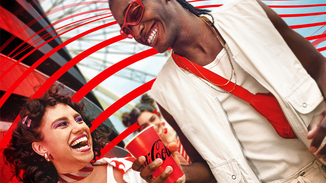 Dos personas disfrutando de una Coca-Cola, sonriendo y riendo. Una persona tiene el pelo rizado con accesorios rosados y lleva una bufanda a rayas, mientras que la otra persona tiene trenzas, usa gafas de sol, un chaleco blanco y una bolsa cruzada roja. Líneas gráficas rojas mejoran el ambiente festivo.