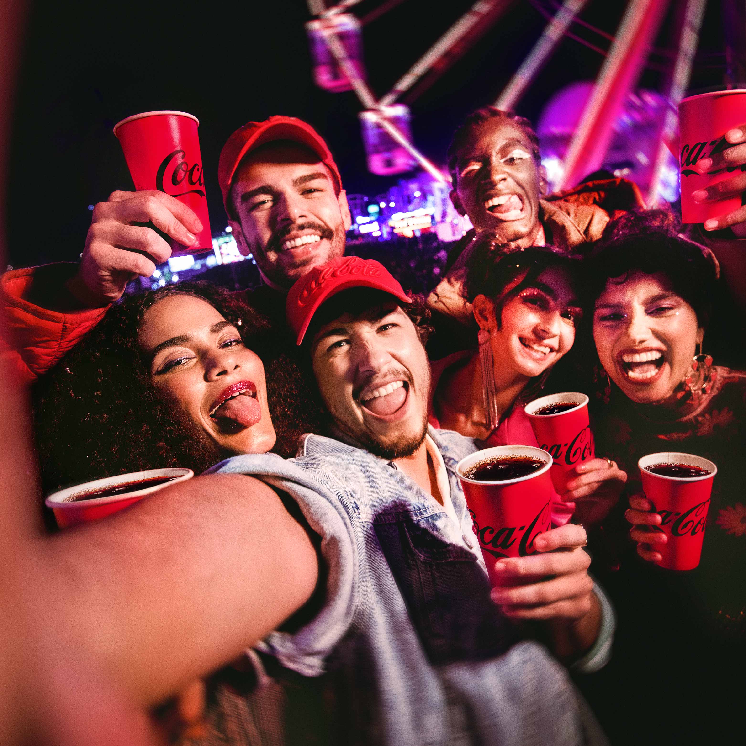 Grupo de jóvenes disfrutando Coca-Cola en un ambiente festivo.