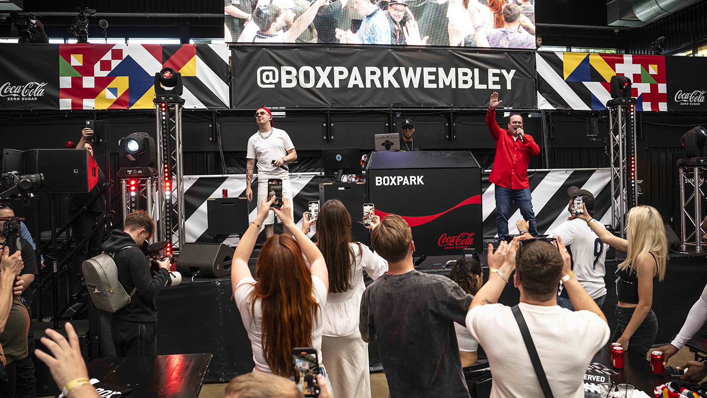 EDITORIAL USE ONLY
Aitch and Shaun Williamson perform Sweet Caroline on the Coca-Cola Zero Sugar stage at BOXPARK in Wembley ahead of England’s UEFA EURO 2024 game against Denmark. Picture date: Thursday June 20, 2024. PA Photo. New research from Coca-Cola Zero Sugar revealed that Sweet Caroline ranked the nation's favourite football anthem, above Three Lions and We Are The Champions. Photo credit should read: John Nguyen/PA Media Assignments