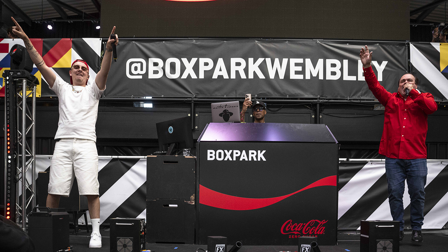 EDITORIAL USE ONLY
Aitch and Shaun Williamson perform Sweet Caroline on the Coca-Cola Zero Sugar stage at BOXPARK in Wembley ahead of England’s UEFA EURO 2024 game against Denmark. Picture date: Thursday June 20, 2024. PA Photo. New research from Coca-Cola Zero Sugar revealed that Sweet Caroline ranked the nation's favourite football anthem, above Three Lions and We Are The Champions. Photo credit should read: John Nguyen/PA Media Assignments