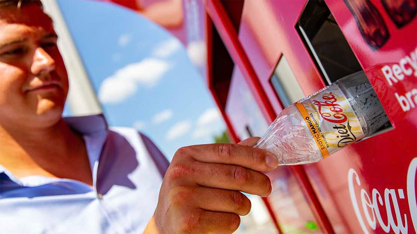 A person recycling a bottle 