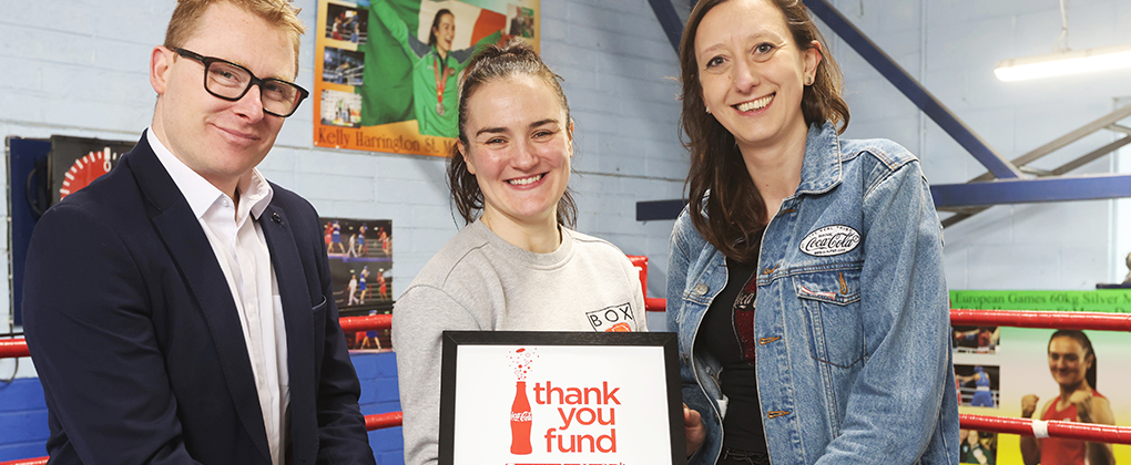 The Thank You Fund poster being held in a boxing ring