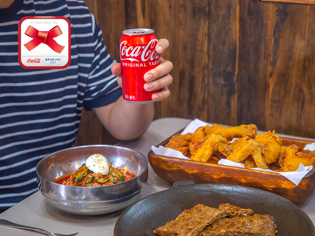 에루화 식당에서 전주의 맛있는 음식과 함께 코카-콜라 캔을 손에 쥐고 있는 이미지