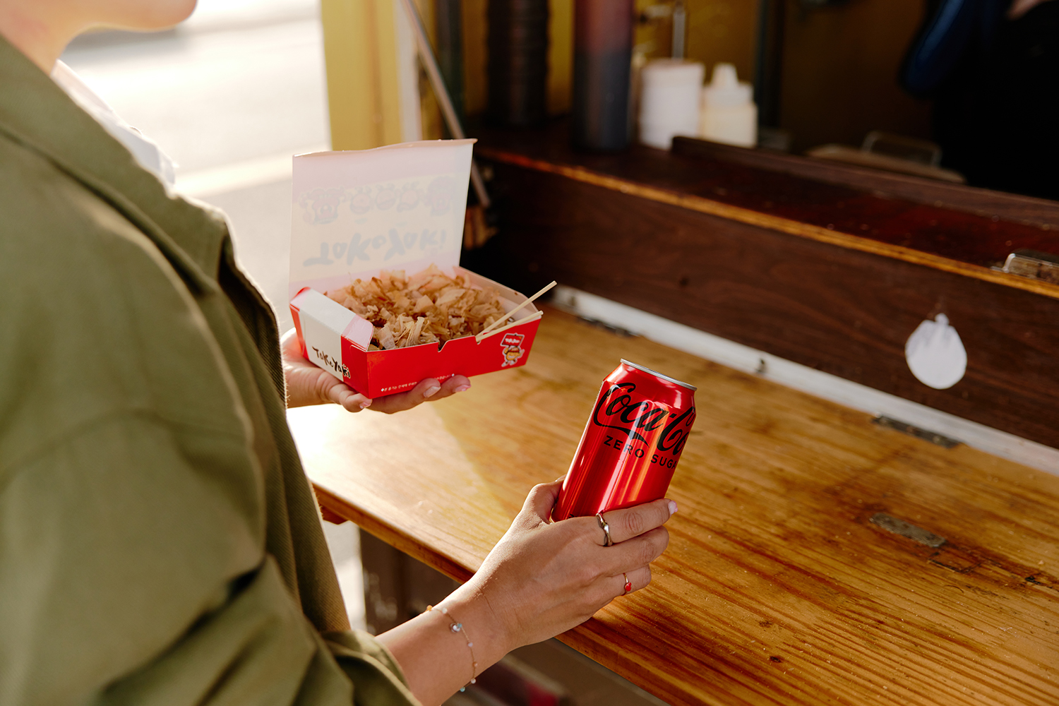 푸드트럭에서 한 손에는 코카-콜라 제로를, 한 손에는 음식을 들고 있다. 