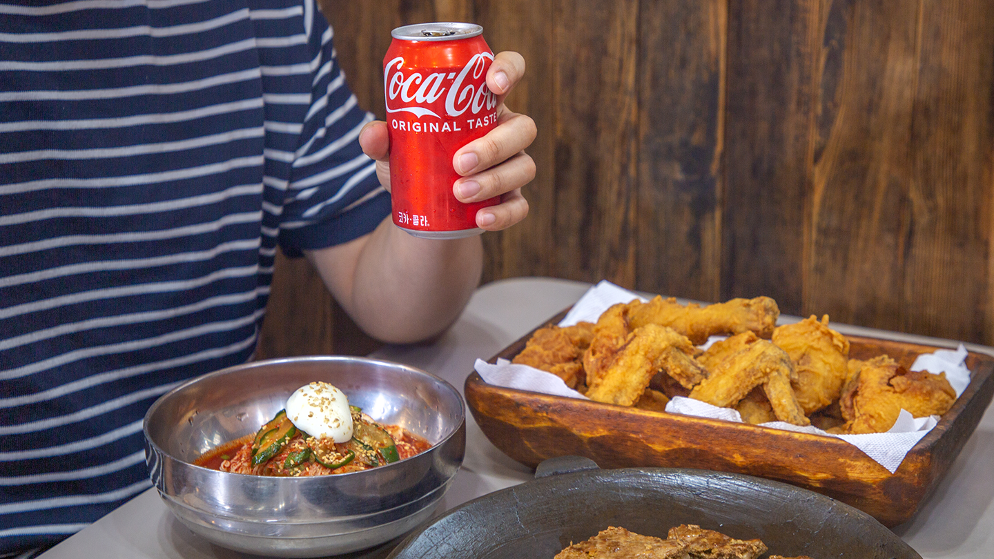 전주의 맛있는 음식과 함께 코카-콜라 캔을 손에 쥐고 있다