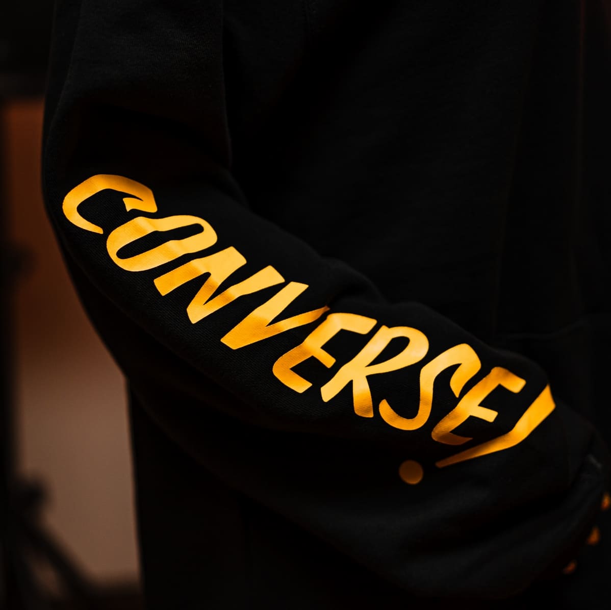Buzo negro con la inscripción "Converse" en color amarillo.