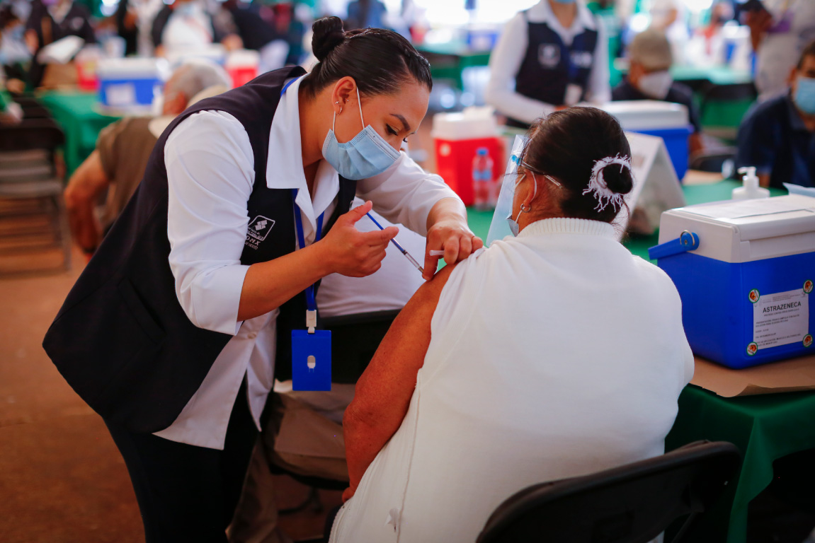 Enfermera vacunando a una mujer en centro de vacunación