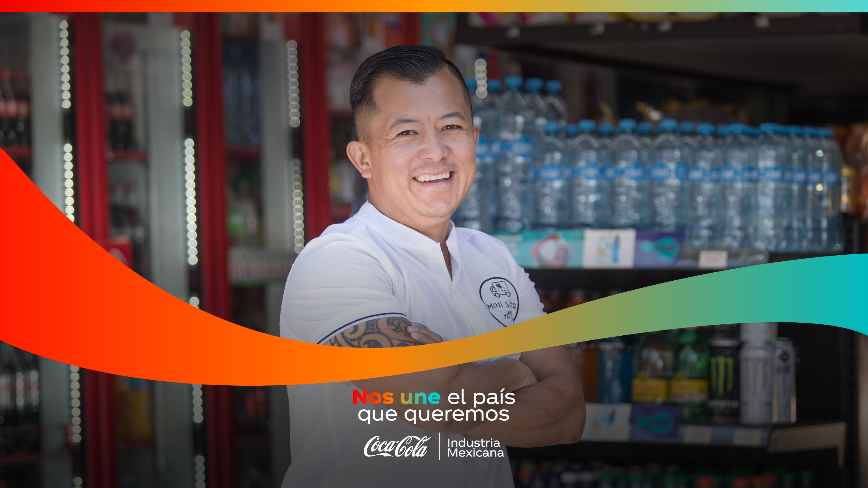 Hombre mirando a cámara sonriente. De fondo se observan productos de Coca-Cola. Se lee la leyenda "Nos une el país que queremos".