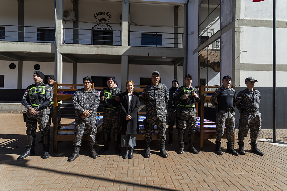 Personal de la policia posando frente a las camas donadas