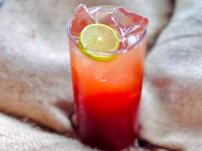 cold brew fizz drink in glass with ice and lemon wedge