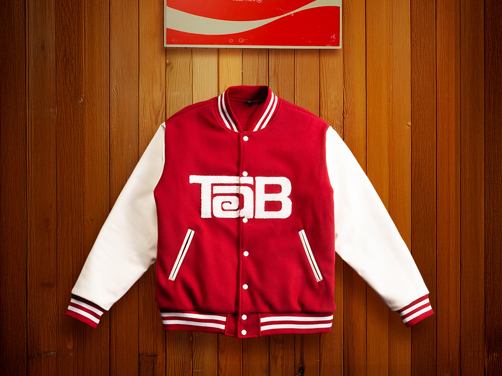 A dark red varsity jacket style jacket with the Tab logo