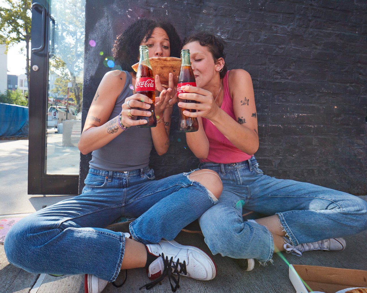 two people sharing food and coca-cola