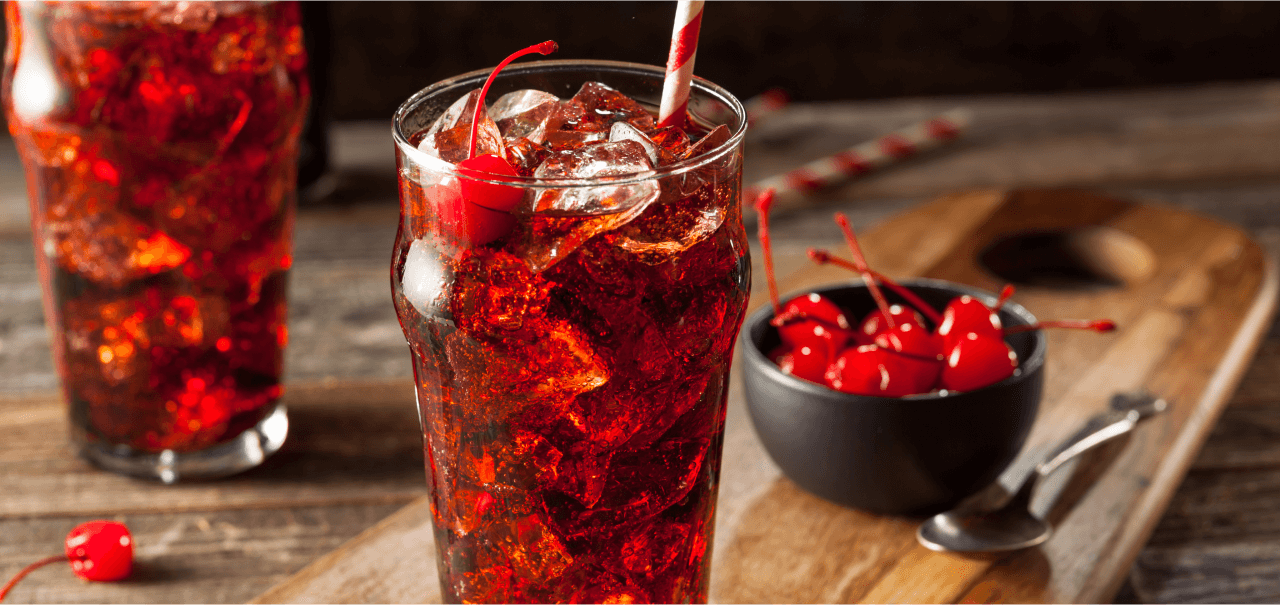 two cola drinks with cherries and straws