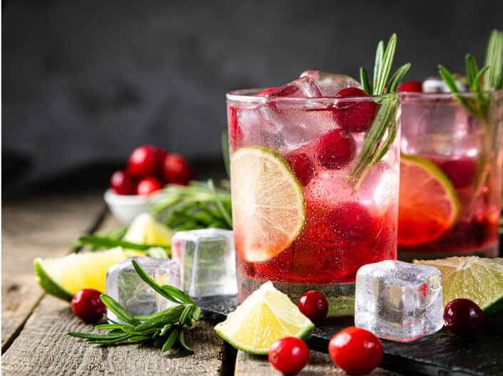 a red drink with cranberries and limes