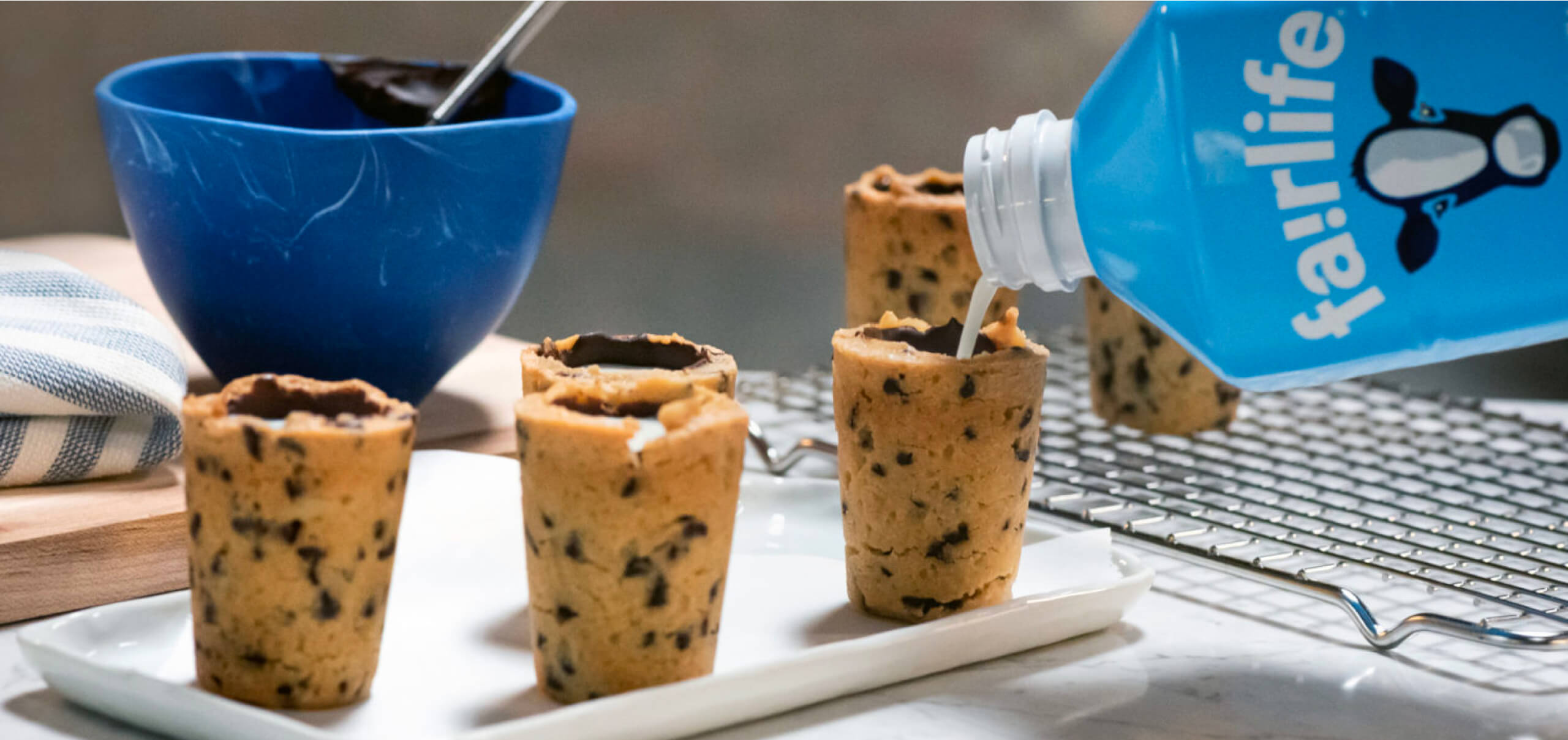 cookies in the shape of cups with fairlife milk being poured in