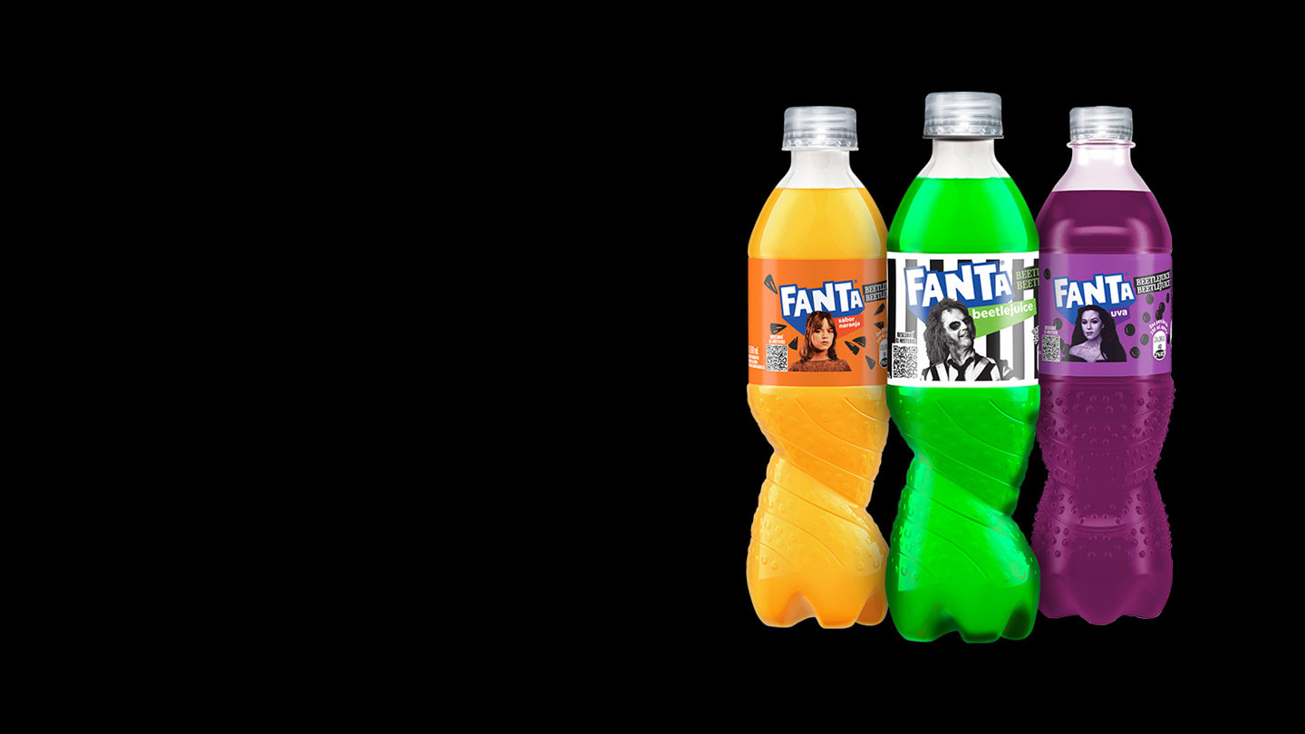 Tres botellas de Fanta de la edición limitada de Beetlejuice, cada una con un sabor y personaje diferente: uva con Delores, frutilla con Lydia Deetz, naranja personalizada con Astrid Deetz, y la misteriosa Fanta con el Beetlejuice en su etiqueta.